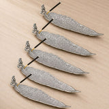 Silver leaf-shaped incense holder with intricate filigree patterns and small ganesha figurine stand for home use