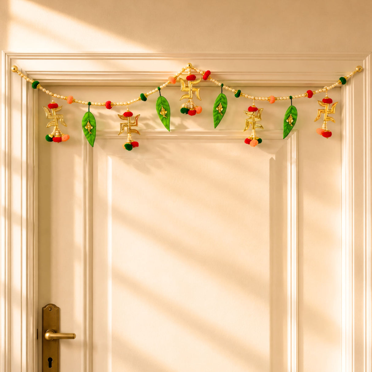 A festive golden and green ganesha multicolor bead door toran with swastika symbols, mango leaf charms, and pompoms