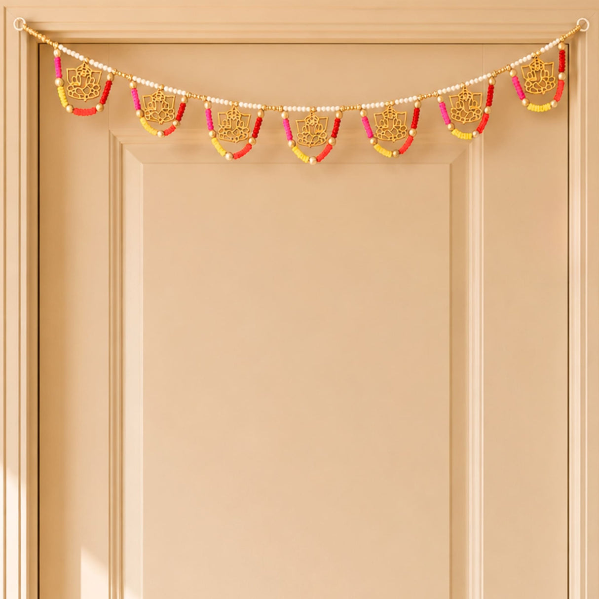 A decorative golden lotus-themed ganesha multicolor bead door toran with pink red and yellow beads for festive decor