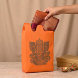 Orange reusable non woven tote bag with dark brown ganesha silhouette for Indian wedding housewarming puja gifts