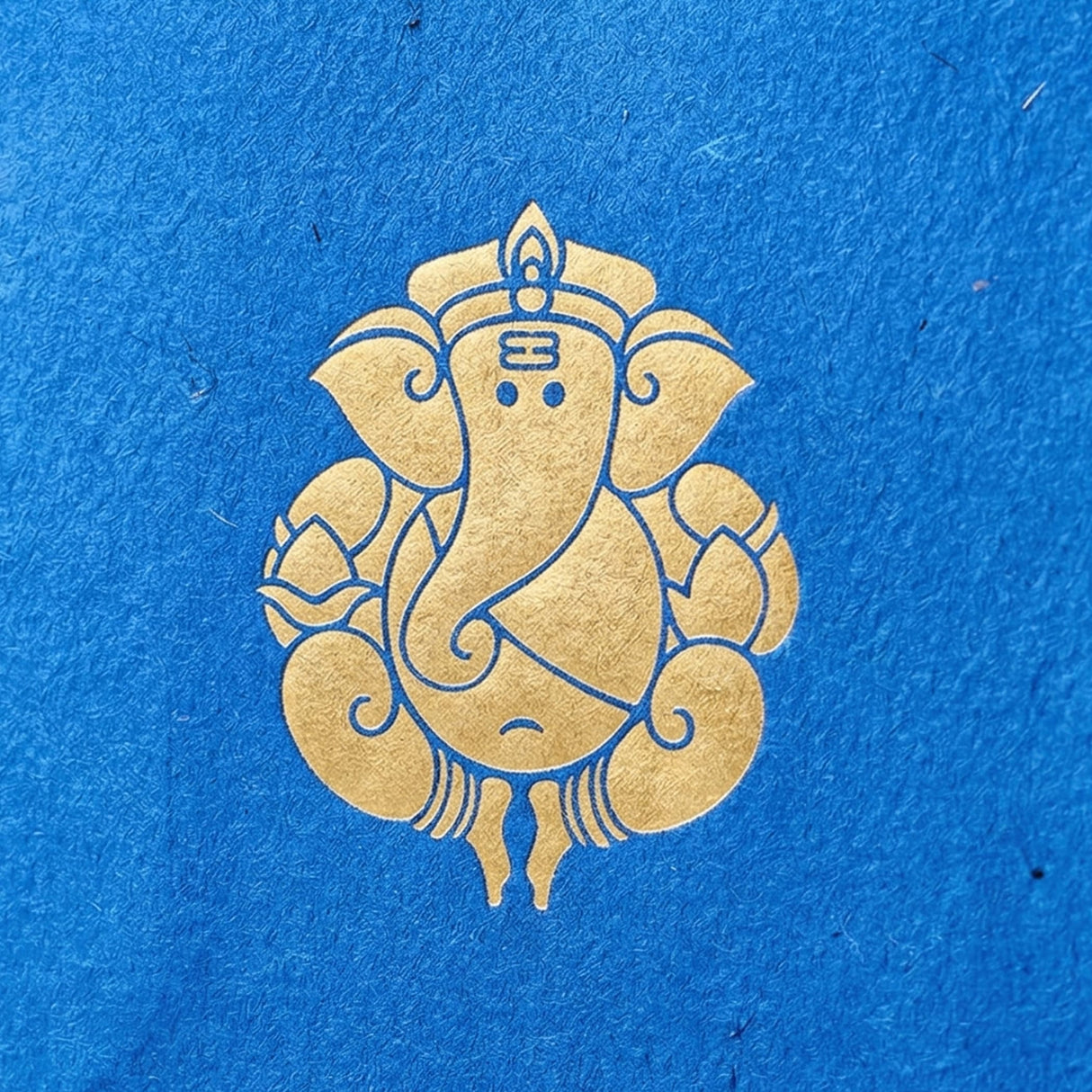 Ganesha paper carry bag featuring golden Ganesha emblem on textured blue paper for wedding and Ganesh Chaturthi gifts