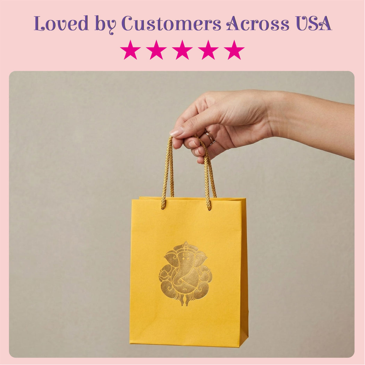 A vibrant yellow paper gift bag with gold foil ganesha design and braided handles for wedding and puja return gifts