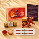 Red and gold embroidered elephant-shaped candle holder with decorative embellishments in designer ganesha rakhi gift hamper