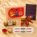 Red and gold embroidered elephant-shaped candle holder with decorative embellishments in designer ganesha rakhi gift hamper
