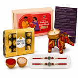 Designer ganesha rakhi gift hamper featuring a red and gold elephant-shaped candle holder with intricate embroidery
