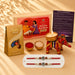 Designer ganesha rakhi gift hamper featuring a red and gold intricate elephant-shaped candle holder for brother and bhabhi