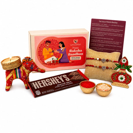 A vibrant red and gold decorative elephant figurine with intricate embroidery in designer ganesha rakhi gift hamper