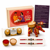 Red elephant-shaped candle holder with gold and rainbow stripes included in designer ganesha rakhi gift hamper