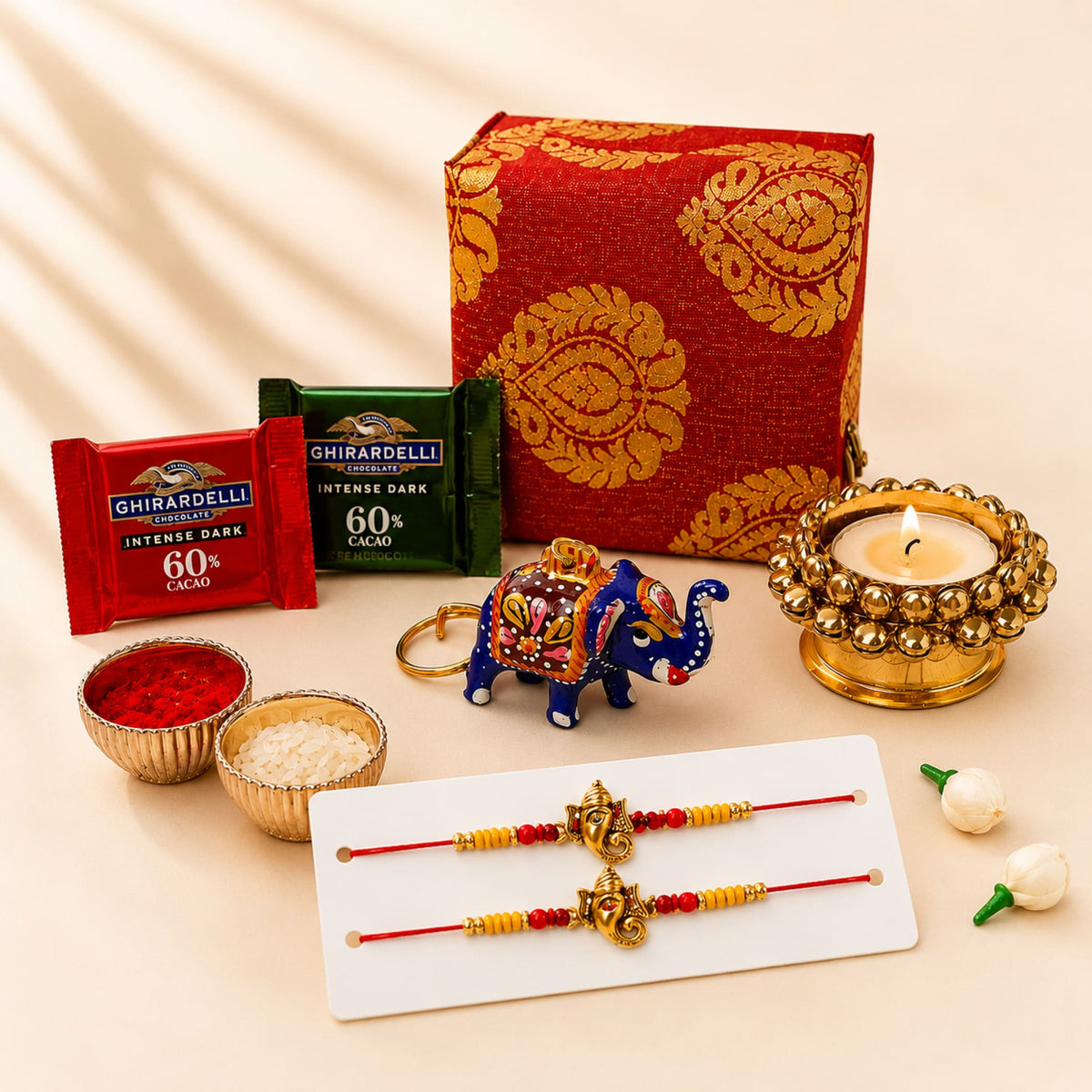 Blue and gold ornate elephant keychain with intricate floral patterns in raksha bandhan brocade gift box hamper