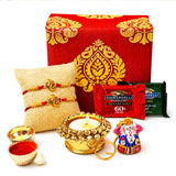 Gold-colored ornate diya candle holder with decorative beads from raksha bandhan brocade gift box hamper for brother and bhabhi