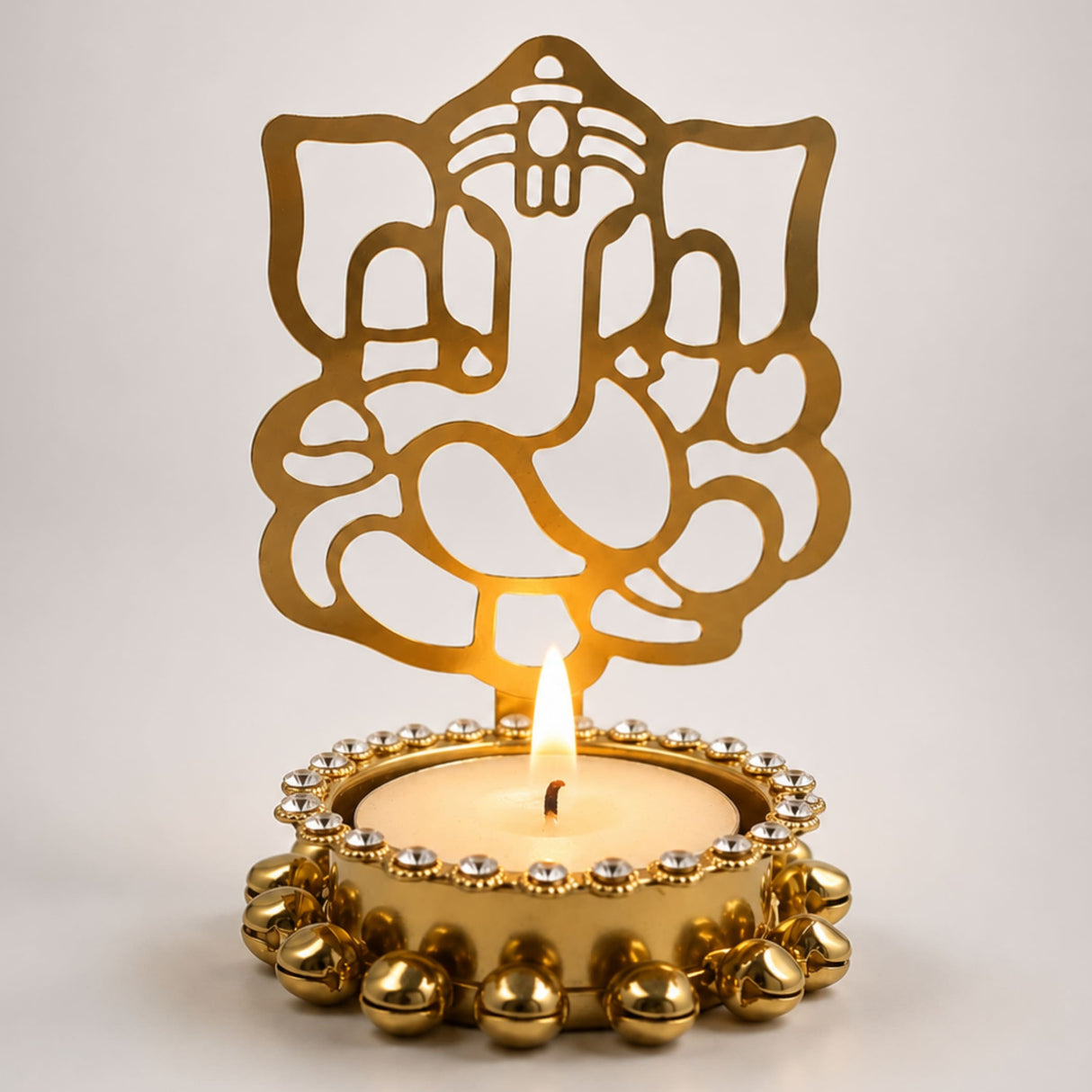 Golden metallic ganesha tea light candle holder with intricate cutout design and beaded embellishments for diwali decor