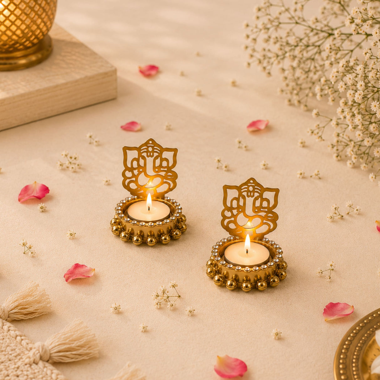 Golden Ganesha shadow diya candle holders with intricate cut-out designs and beaded edges holding lit tea lights