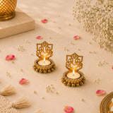 Golden Ganesha shadow diya candle holders with intricate cut-out designs and beaded edges holding lit tea lights