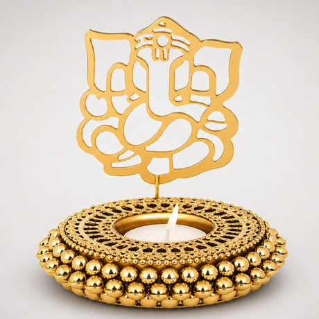 Golden ganesha-themed tealight candle holder with intricate cut-out design and beaded base for festive home decor