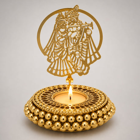 Golden ornamental tealight candle holder with intricate cut-out of figure playing flute and beaded base for festive decor