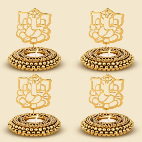 Golden ganesha-themed tealight candle holders with intricate cut-out designs and beaded edges for festive decor