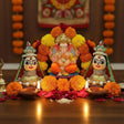 Orange marigold garland with Riddhi Siddhi idols for Diwali decor