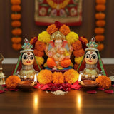 Orange marigold garland with Riddhi Siddhi idols for Diwali decor