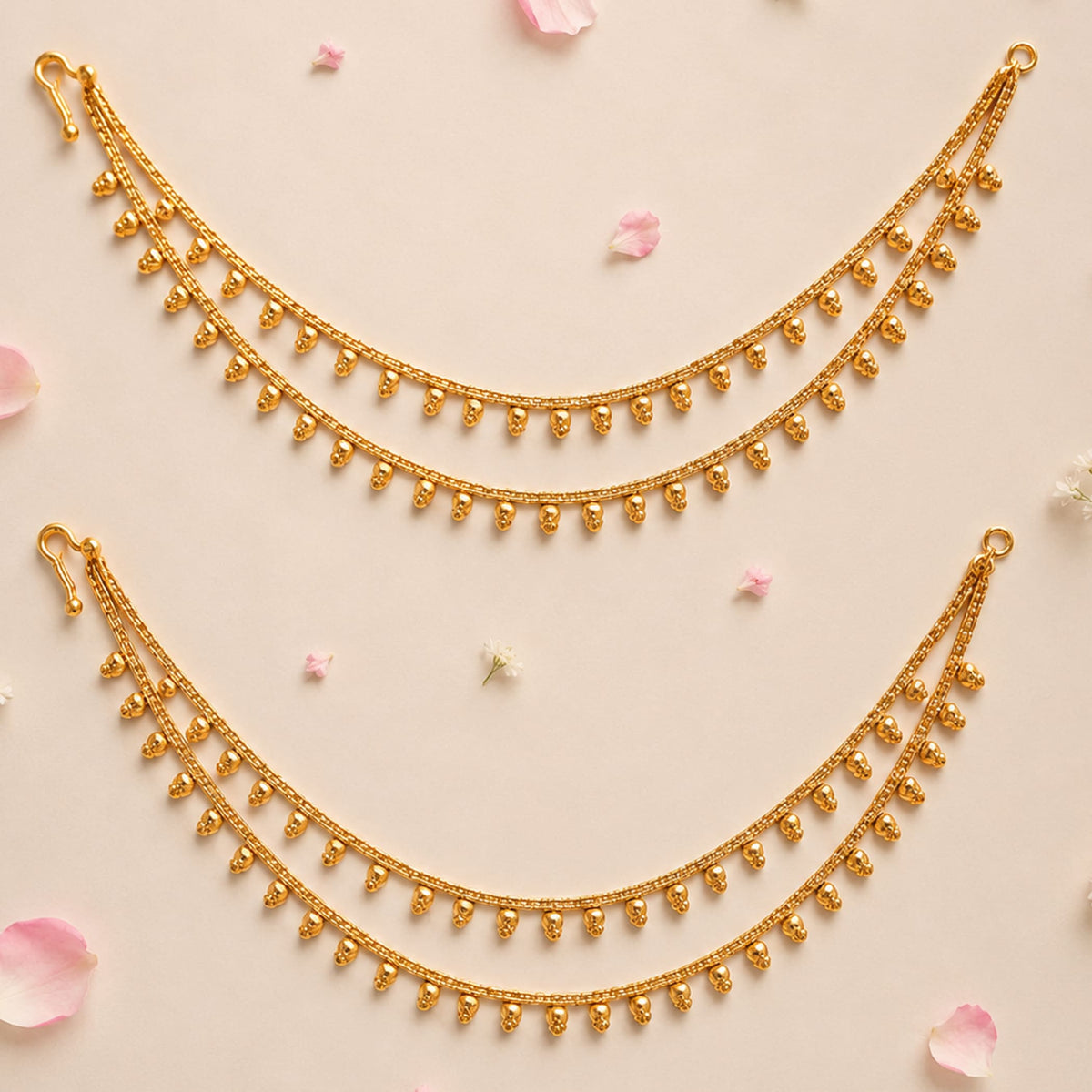 Golden triple strand anklet with small skull charms and hook closure in elegant indian bridal jewelry style