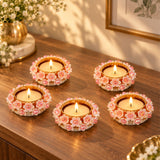 Decorative round gold-tone tealight candle holders with white floral design pink centers and crystal embellishments