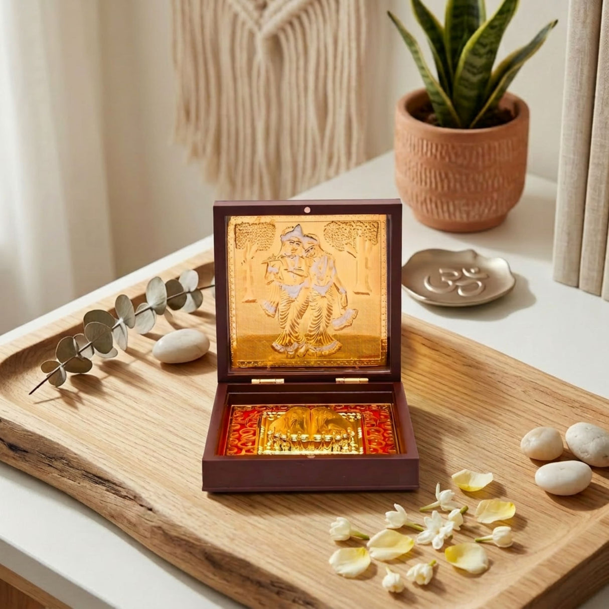 Gold plated laxmi ganesha radha krishna couple in traditional attire inside an open dark brown wooden box with red lining