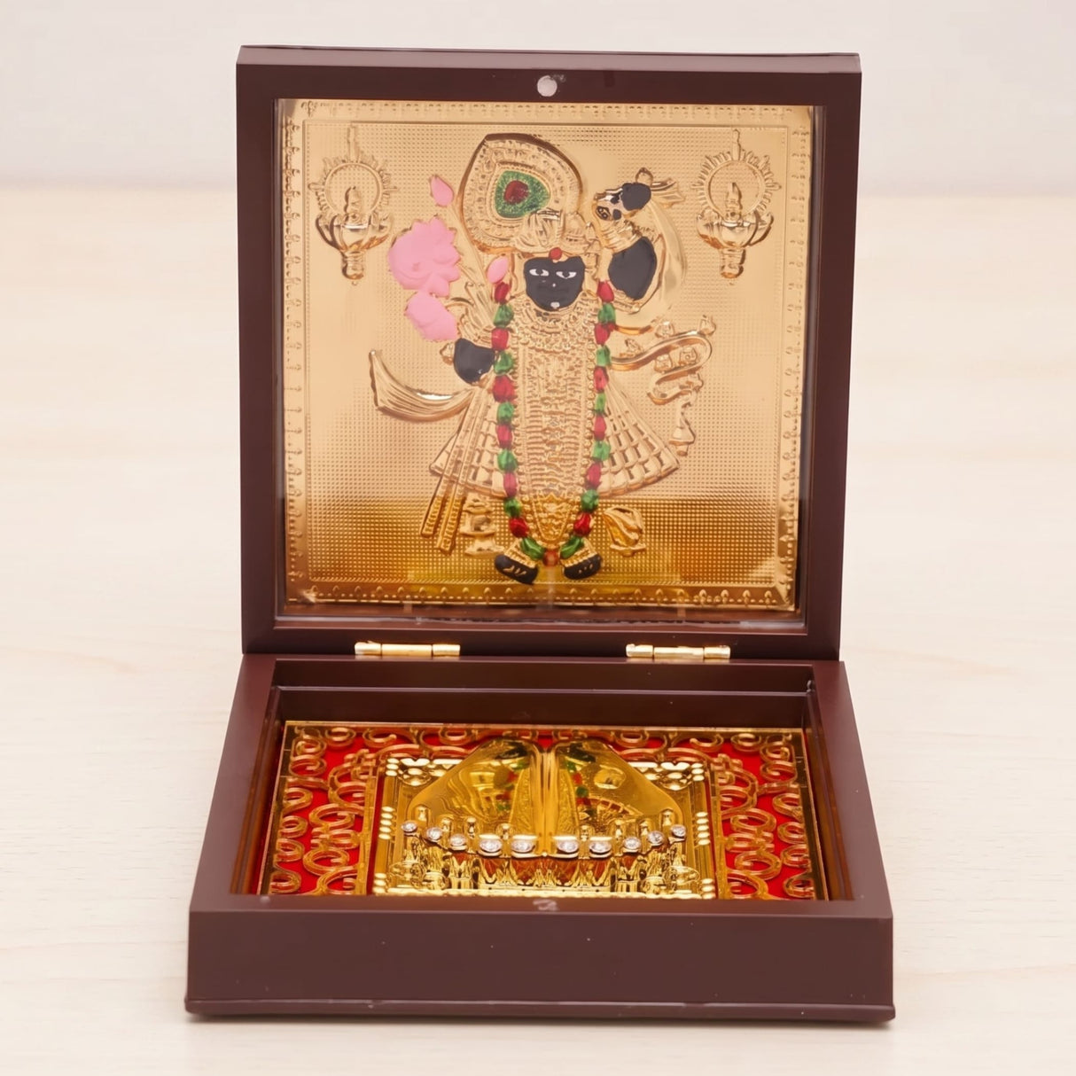 Gold plated laxmi ganesha deity figurine with colorful embellishments in a dark brown wooden pooja box for diwali gift