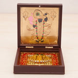Gold plated laxmi ganesha deity figurine with colorful embellishments in a dark brown wooden pooja box for diwali gift