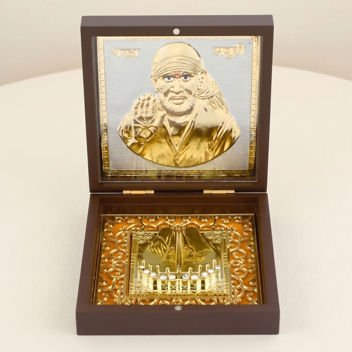 Gold plated sai baba portrait in a golden metallic finish within a dark brown wooden box with ornate gold detailing for pooja decor