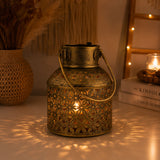 Antique brass lantern tealight candle stand with intricate floral cutouts and sturdy handle glowing warmly inside