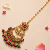 Gold plated chand tikka maang tikka with ornate floral design and vibrant pink green gemstones for traditional weddings