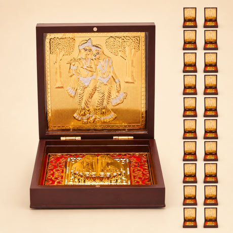 Gold plated radha krishna photo frame with golden ornate embossed lid and intricate diorama on red base for spiritual decor