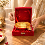 A golden german silver bowl with intricate engravings in a red velvet box for pooja and festive serving