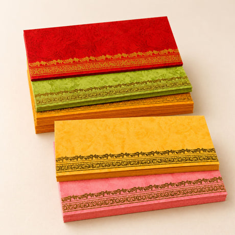 Stacks of colorful money envelopes with decorative golden borders in red green yellow and pink for cash gifts and savings