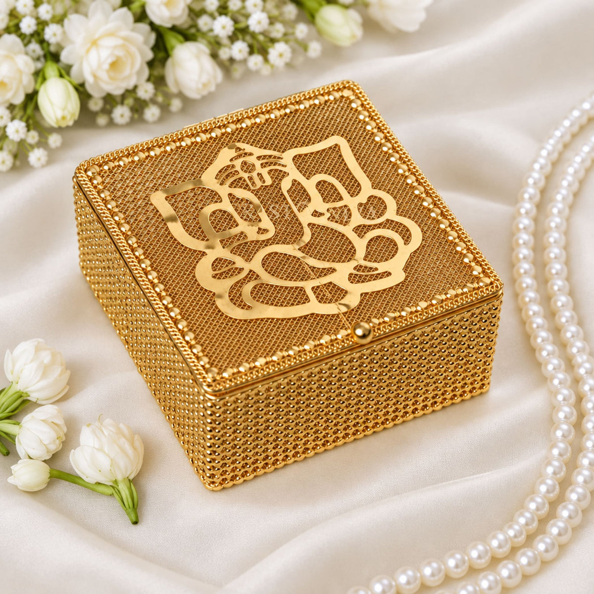 Decorative golden gift box with mesh texture and ornate ganesha cutout lid for traditional indian wedding and festive gifts