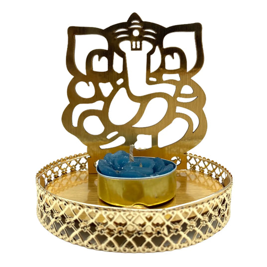 Golden Ganesha-shaped candle holder with a blue tealight on a decorative metal tray.