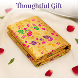 Folded golden-yellow silk unstitched meenakari blouse piece with pink green and purple floral embroidery for saree use