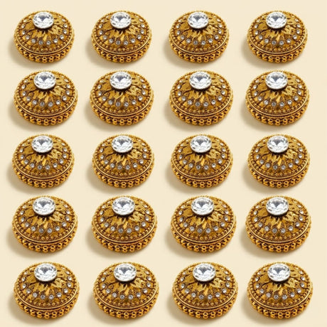 Golden metallic kumkum holder with ornate golden buttons featuring embossed patterns and clear rhinestones for pooja