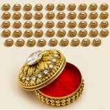 Golden ornate metallic kumkum holder jewelry box with red velvet interior and crystal embellishments for Indian pooja