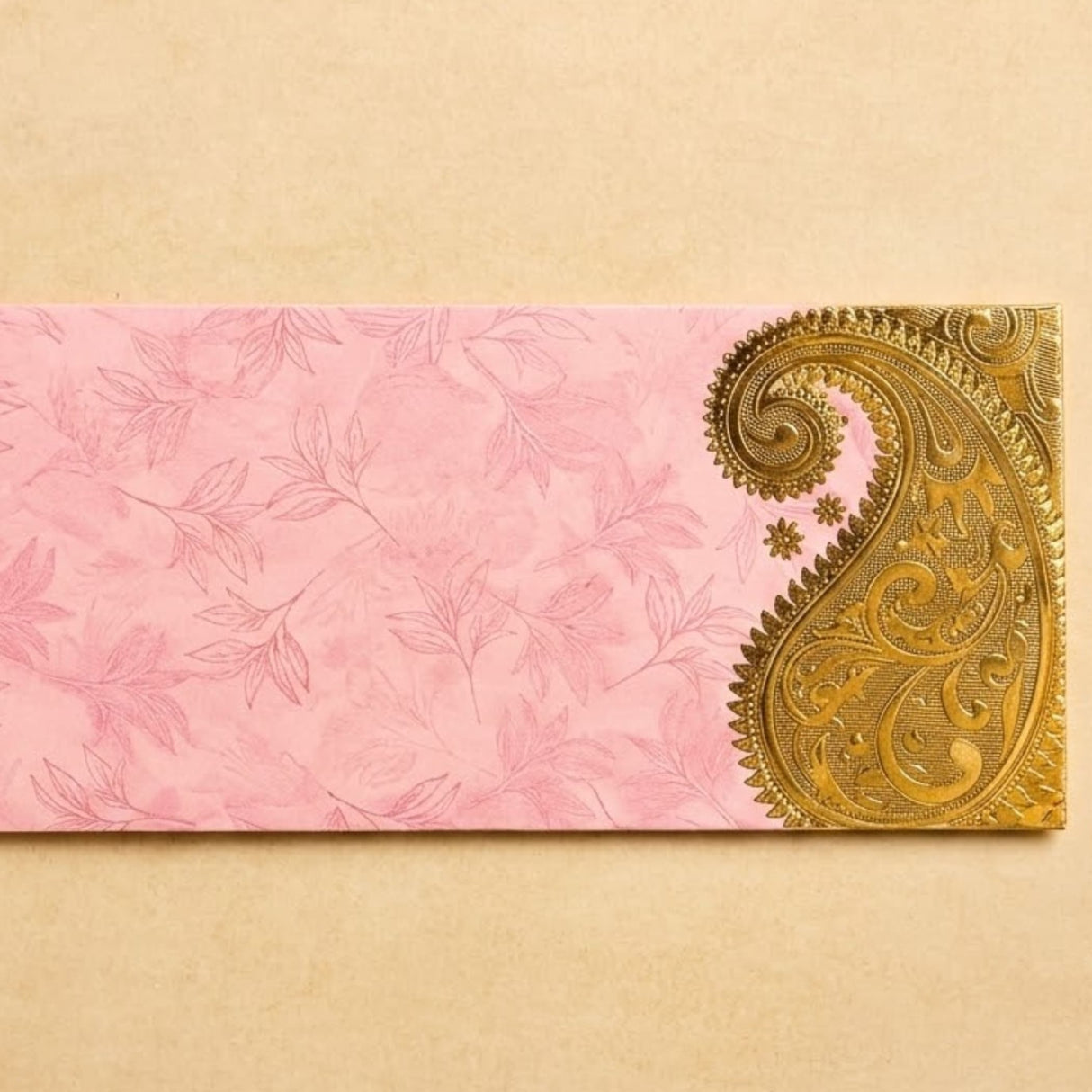 Pink money envelope with delicate leaf patterns and ornate golden paisley design for indian wedding cash gifts