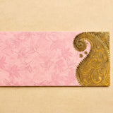 Pink money envelope with delicate leaf patterns and ornate golden paisley design for indian wedding cash gifts
