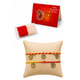 Set of three colorful braided friendship bracelets with gold-toned coin charms on beige cushion for Raksha Bandhan gift