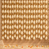 Beige sheer net fabric fans with gold toned metal accents hanging as decorative garland for diwali eid and wedding decor