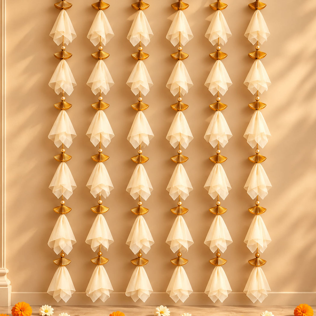 Elegant white sheer fabric tassels with gold-toned fan metal accents hanging in the gotta patti net backdrop for diwali eid wedding decor