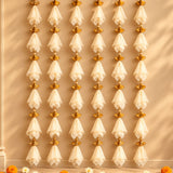 Elegant white sheer fabric tassels with gold-toned fan metal accents hanging in the gotta patti net backdrop for diwali eid wedding decor