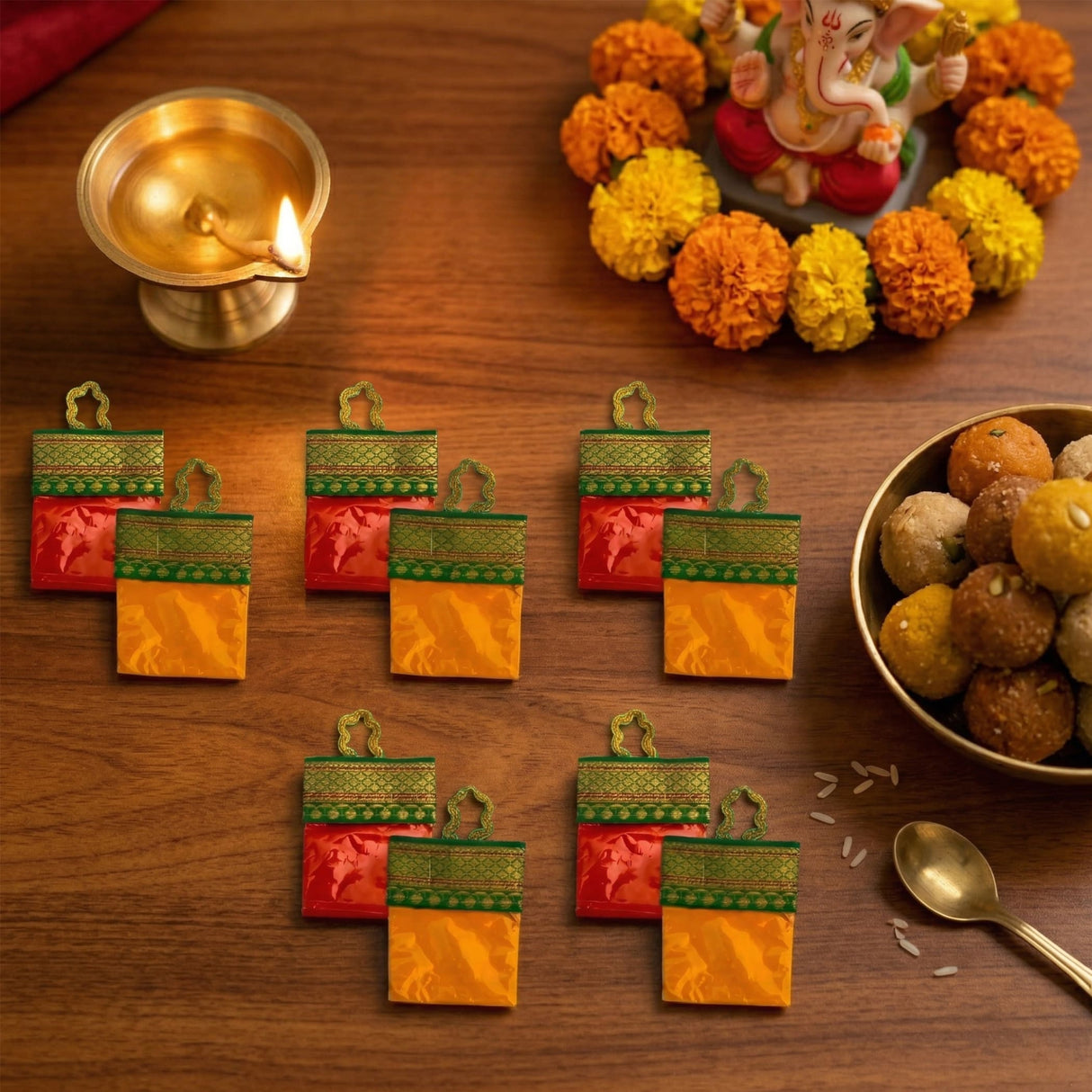 Vibrant red and gold patterned haldi kumkum fabric pouches with green embroidered borders for indian wedding thamboolam set