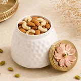 White ceramic nut jar with hammered texture and gold-toned floral lid with rose-gold petals for decorative use