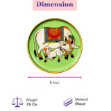 Decorative green wooden plate with gold rim featuring hand painted white cows in red and blue for wall décor