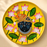 Vibrant yellow hand painted wooden decorative plate with dark skinned deity and lotus flowers for wall decor