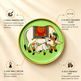 Hand painted indian 8 inch wooden plate featuring white cows with red and gold blankets on green background for wall décor