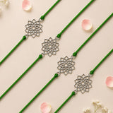 Four green cord designer lotus charm rakhis with silver toned openwork floral pendants for raksha bandhan gift